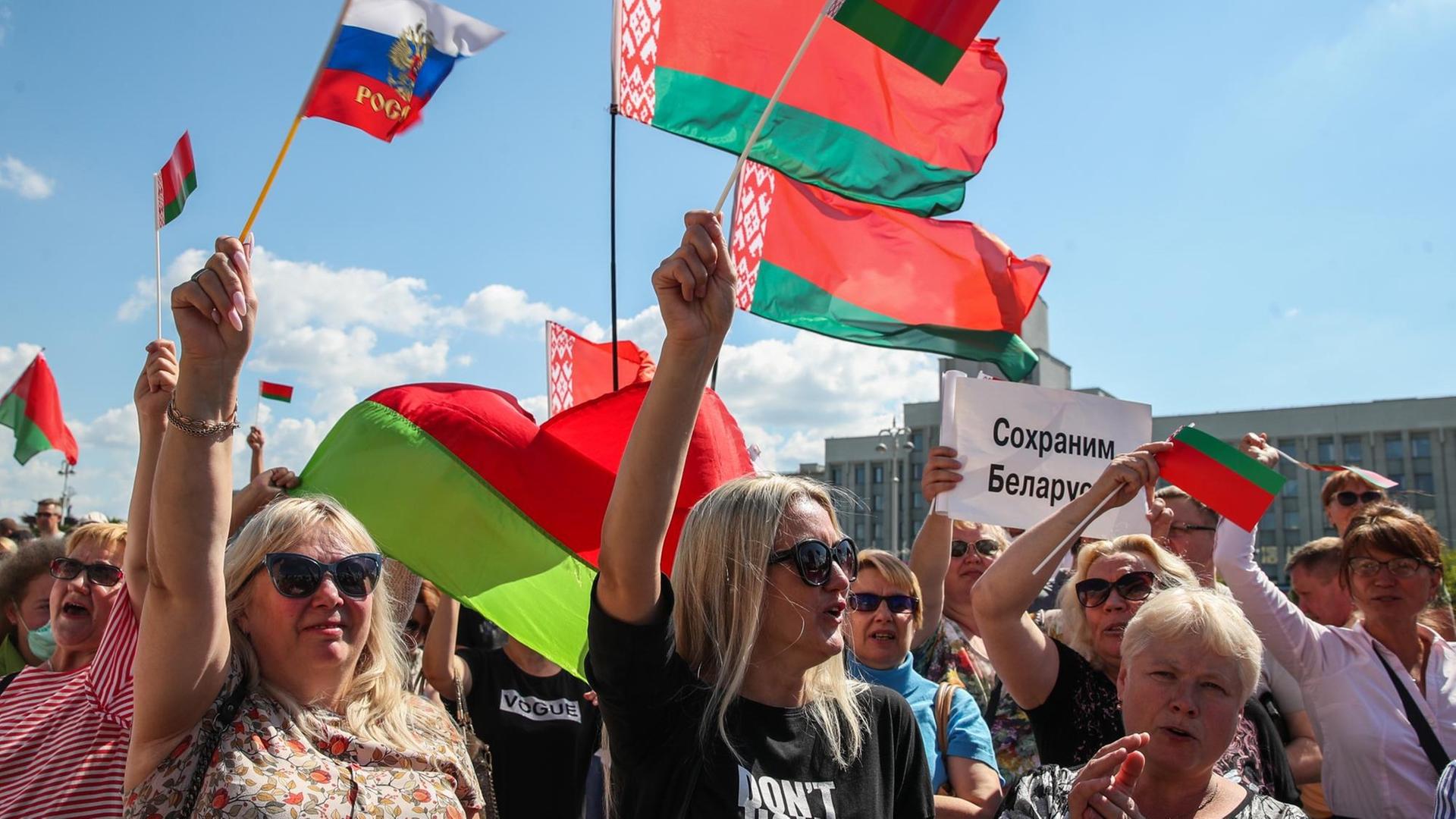 Demonstrierende auf dem Unabhängigkeitsplatz in Minsk, die für den Präsidenten Alexander Lukaschenko protestieren. Auf einem Schild steht "Lasst uns Belarus retten".
