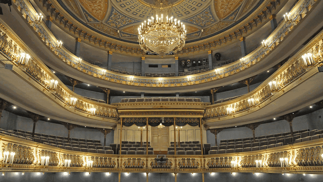 Innenansicht des historischen Landestheaters Coburg mit seinen beleuchteten Rängen, die golden erscheinen.