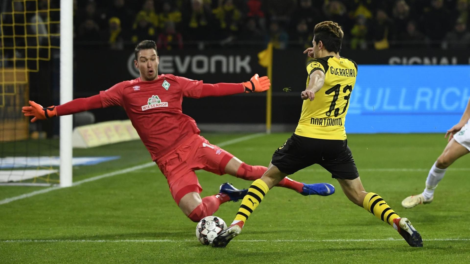 Raphael Guerreiro im gelb-schwarzen Trikot von Dortmund und Torwart Jiri Pavlenka von Bremen im Zwei-Kampf. Raphael Guerreiro im gelb-schwarzen Trikot von Dortmund und Torwart Jiri Pavlenka von Bremen im Zwei-Kampf.
