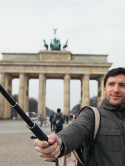 Zwei italienische Touristen machen am am Brandenburger Tor in Berlin ein Selbstporträt mit einem "Selfie-Stick".
