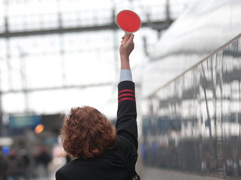 Zugbegleiterin der Deutschen Bahn Fernverkehr fertigt einen abfahrbereiten ICE im Hauptbahnhof Frankfurt ab