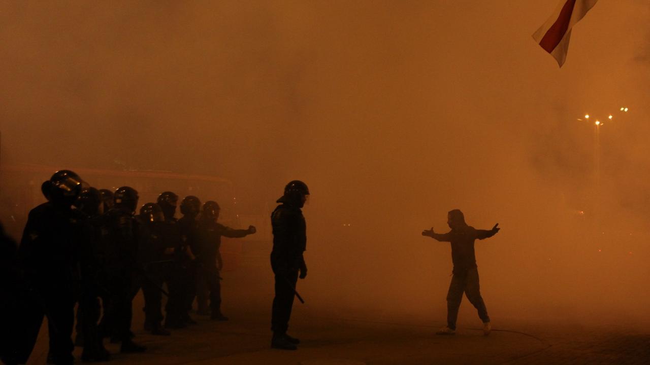 In großen Rauchschwaden veersperren eine Reihe von Polizisten einem Demonstranten den Weg.