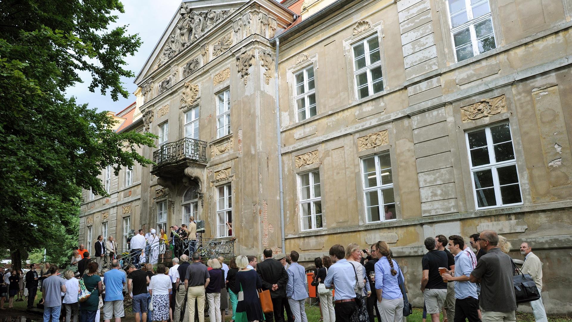 Kunstinteressierte vor dem Schloss in Roskow in Brandenburg: Sie warten auf die Eröffnung der Ausstellung "Rohkunstbau"; Aufnahme vom August 2013