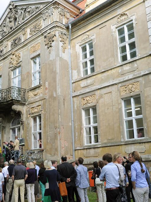 Kunstinteressierte vor dem Schloss in Roskow in Brandenburg: Sie warten auf die Eröffnung der Ausstellung "Rohkunstbau"; Aufnahme vom August 2013