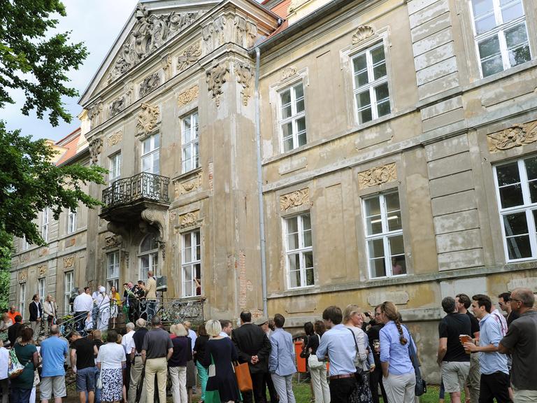 Kunstinteressierte vor dem Schloss in Roskow in Brandenburg: Sie warten auf die Eröffnung der Ausstellung "Rohkunstbau"; Aufnahme vom August 2013