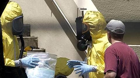 Arbeiter in Schutzanzügen bei einer Durchsuchung des Verlagsgebäudes von "The National Enquirer" in Florida, das 2002 Ziel einer Anthrax-Attacke war.