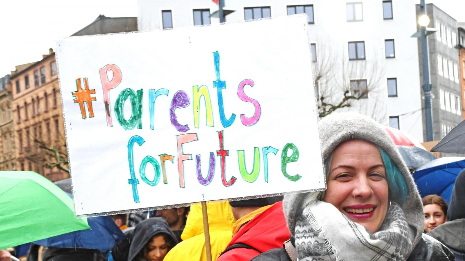 Monika Snela-Deschermaier hält ein Protestplakat mit der Aufschrift "Parents for future" in die Höhe.