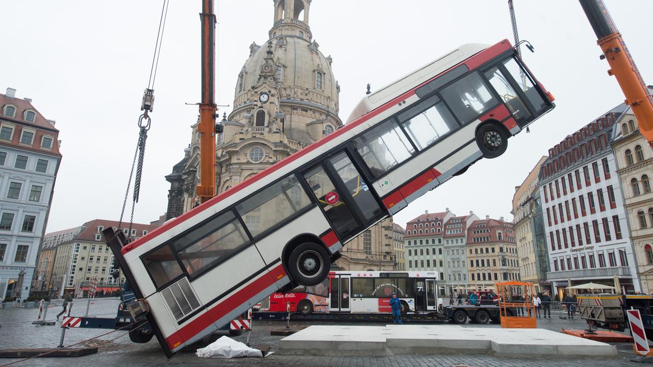 Ein Linienbus wird am 6.2.2017 auf dem Neumarkt vor der Frauenkirche in Dresden von einem Kran in eine senkrechte Position gehoben.