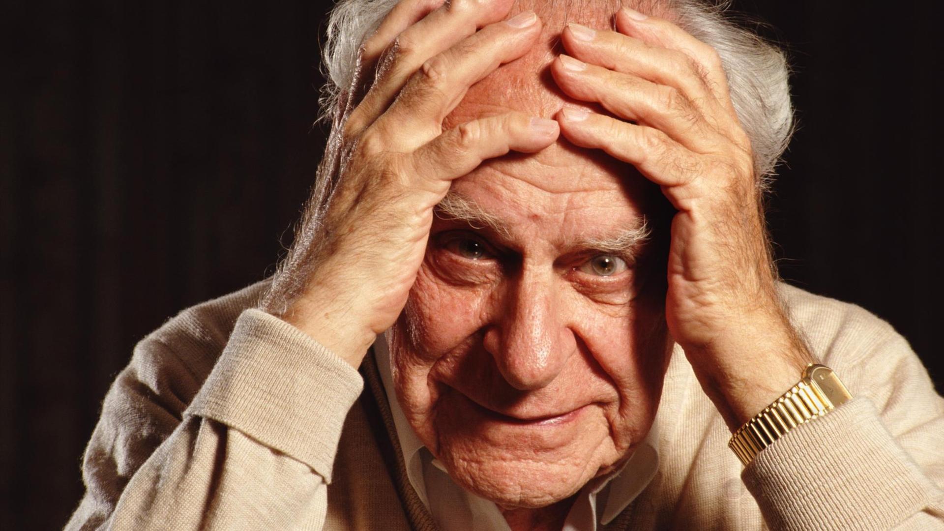 Der Philosoph Sir Karl Popper (1902 - 1994) posiert am 31. August 1992 in seinem Haus in Croydon, London, England. Er hält sich beide Hände an die Stirn und blickt fragend.