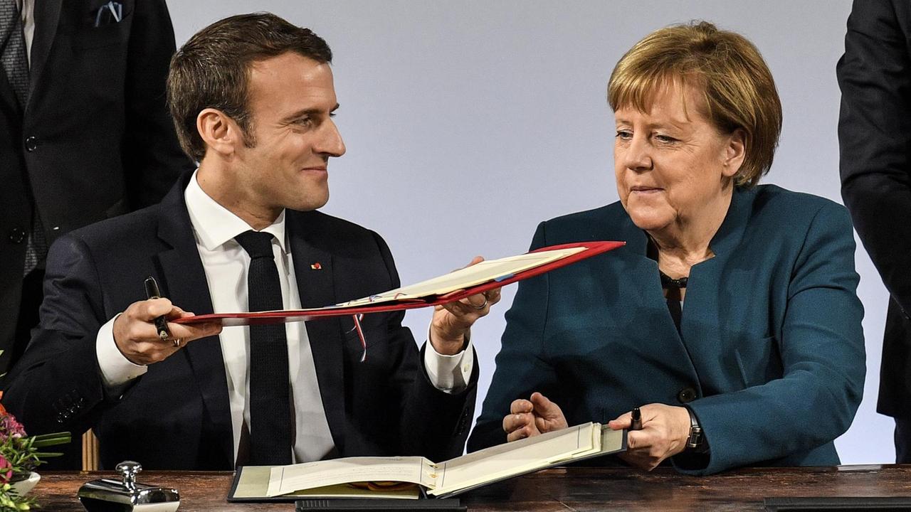 Der französische Staatspräsident Macron und Bundeskanzlerin Merkel unterzeichnen den Aachener Vertrag