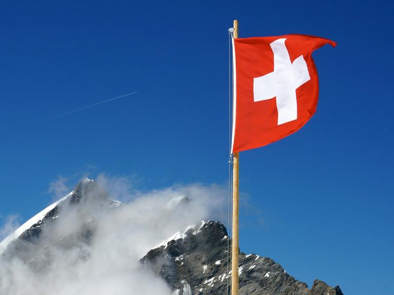 Die Schweizer Flagge weht nahe dem Jungfraujoch in den Berner Alpen in der Schweiz