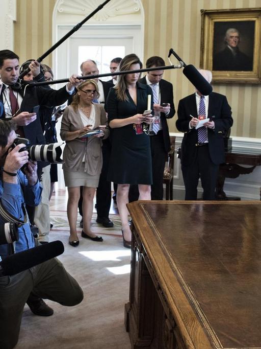Sie sehen US-Präsident Donald Trump. Er spricht im "Oval Office" des Weißen Hauses zu Reportern über eines seiner Dekrete.