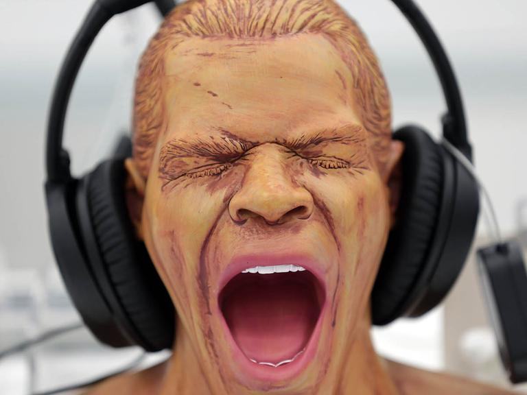 Ein Kopfhörer für digitale Musik hängt in Köln in einem Geschäft auf einer Figur.