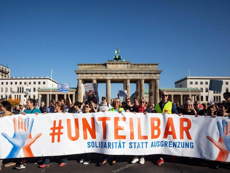 13.10.2018, Berlin: Der Zug der Demonstration gegen Rassismus und Rechtsruck mit dem Motto «Unteilbar» zieht vor das Brandenburger Tor