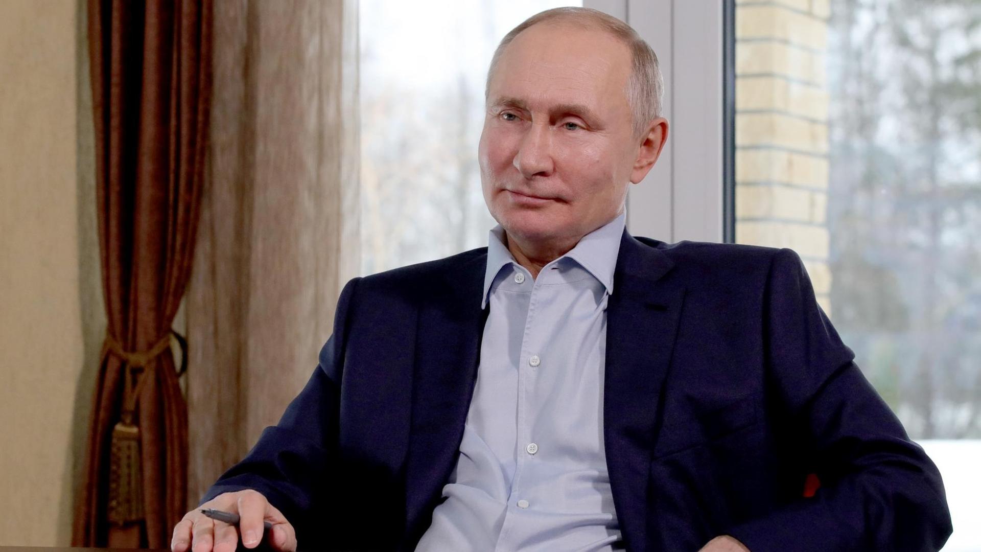 Wladimir Putin, Präsident von dem Land Russland, sitzt in einem Stuhl.