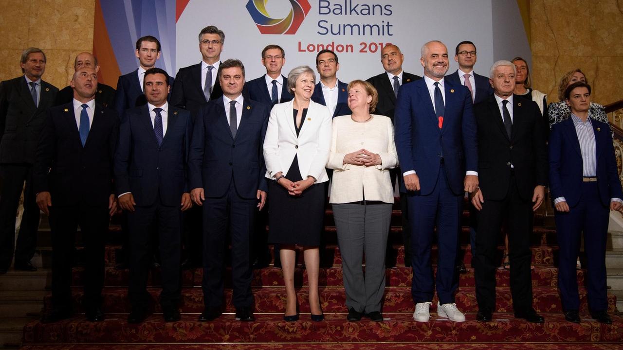 Theresa May (Mitte l), Premierministerin von Großbritannien, und Bundeskanzlerin Angela Merkel (Mitte r) stellen sich mit ihren Amtskollegen und Delegierten für ein Gruppenbild im Rahmen des Balkangipfels auf. Bei dem Gipfeltreffen in London steht die Heranführung von Albanien, Bosnien-Herzegowina, Mazedonien, Montenegro, Serbien und des Kosovos an die Europäische Union im Fokus der Gespräche. Bild vom 10. Juli 2018