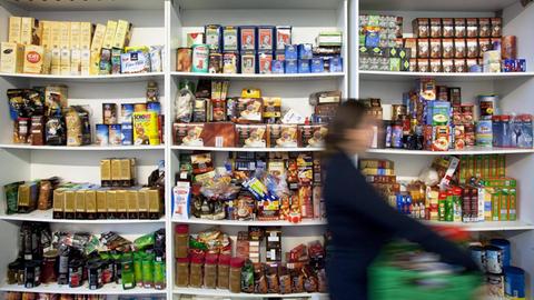 Eine ehrenamtliche Mitarbeiterin stellt eine Spende für die Tafel zusammen