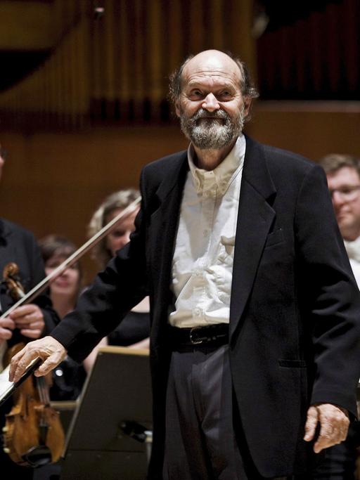 Der estnische Komponist Arvo Pärt im Jahr 2008, im Hintegrund die Musiker eines Sinfonie-Orchesters.