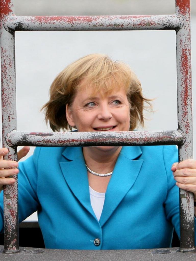 Bundeskanzlerin Angela Merkel (CDU) steigt am 31.08.2006 bei ihrem Besuch der Marine in Rostock-Warnemünde durch eine Luke in das U-Boot des neuen Typs 212 A. Nach der Besichtigung des U-Boots startet sie zu einer mehrstündige Fahrt an Bord der Fregatte «Sachsen». Merkel will sich nach Angaben der Marine über den Einsatzausbildungsverband der Flotte informieren, der derzeit mit zwei Fregatten, sechs Schnellbooten, zwei Minen-Jagdbooten und einem U-Boot sein jährliches Manöver in der Ostsee abhält. Foto: Jens Büttner +++(c) dpa - Report+++