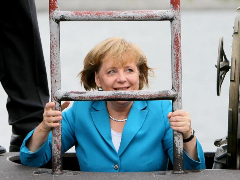 Bundeskanzlerin Angela Merkel (CDU) steigt am 31.08.2006 bei ihrem Besuch der Marine in Rostock-Warnemünde durch eine Luke in das U-Boot des neuen Typs 212 A. Nach der Besichtigung des U-Boots startet sie zu einer mehrstündige Fahrt an Bord der Fregatte «Sachsen». Merkel will sich nach Angaben der Marine über den Einsatzausbildungsverband der Flotte informieren, der derzeit mit zwei Fregatten, sechs Schnellbooten, zwei Minen-Jagdbooten und einem U-Boot sein jährliches Manöver in der Ostsee abhält. Foto: Jens Büttner +++(c) dpa - Report+++