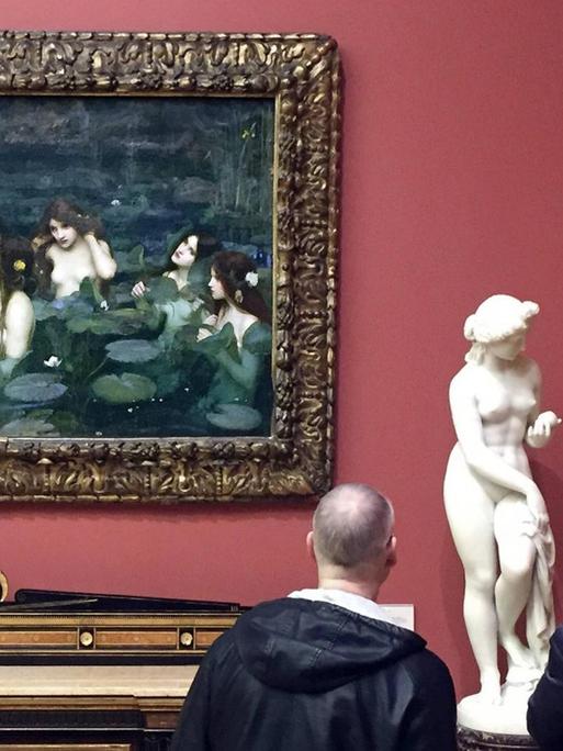 Das Bild zeigt das Gemälde "Hylas and the Nymphs" von John William Waterhouse aus dem Jahre 1896 und eine antike Büste in der Manchester Art Gallery.