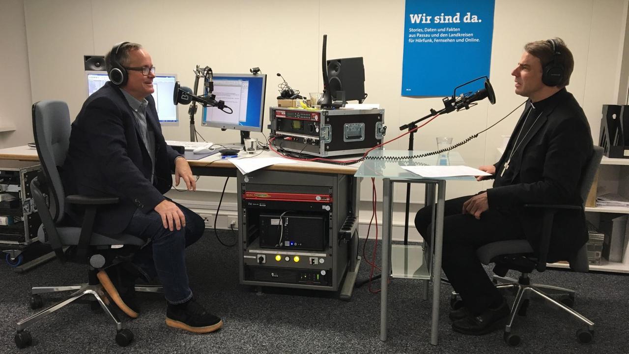 Bischof Stefan Oster sitzt im Studio des Bayerischen Rundfunks Andreas Main gegenüber