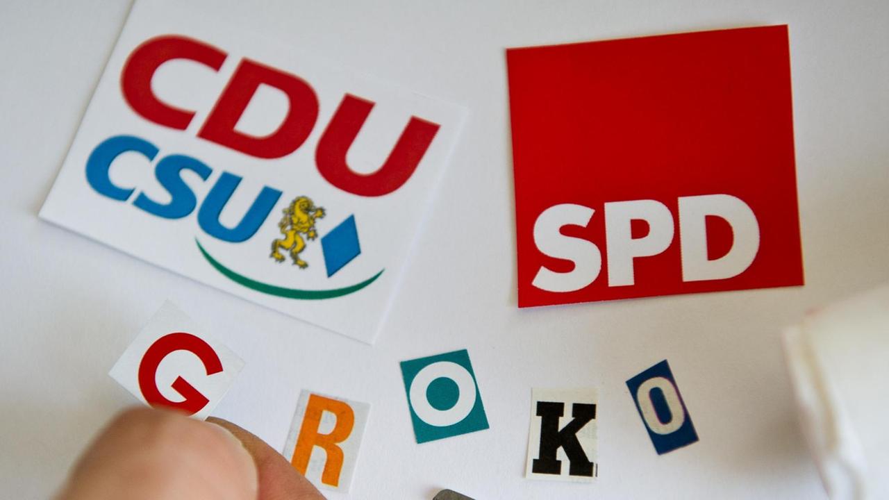 "GroKo" aus ausgeschnittenen Buchstaben zusammen mit den Logos der Parteien CDU/CSU und SPD