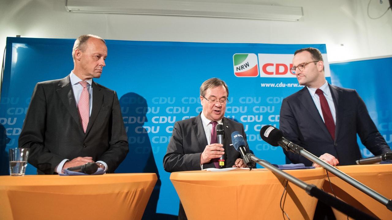 Friedrich Merz (l-r), Armin Laschet, Ministerpräsident von Nordrhein-Westfalen und Jens Spahn, Bundes-Gesundheitsminister sitzen bei einer Pressekonferenz gemeinsam auf dem Podium.