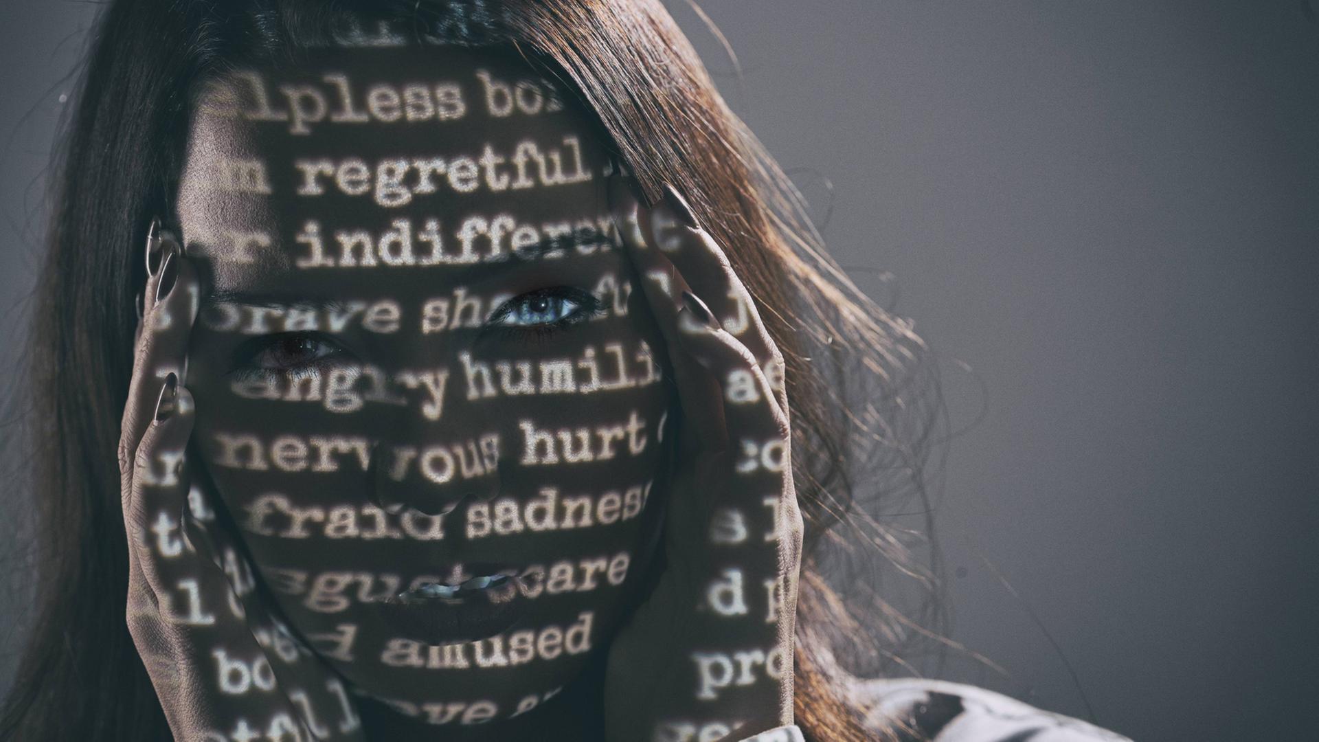 Frau mit geschriebenen Wörtern im Gesicht als Symbolbild für Depressionen und Hilflosigkeit