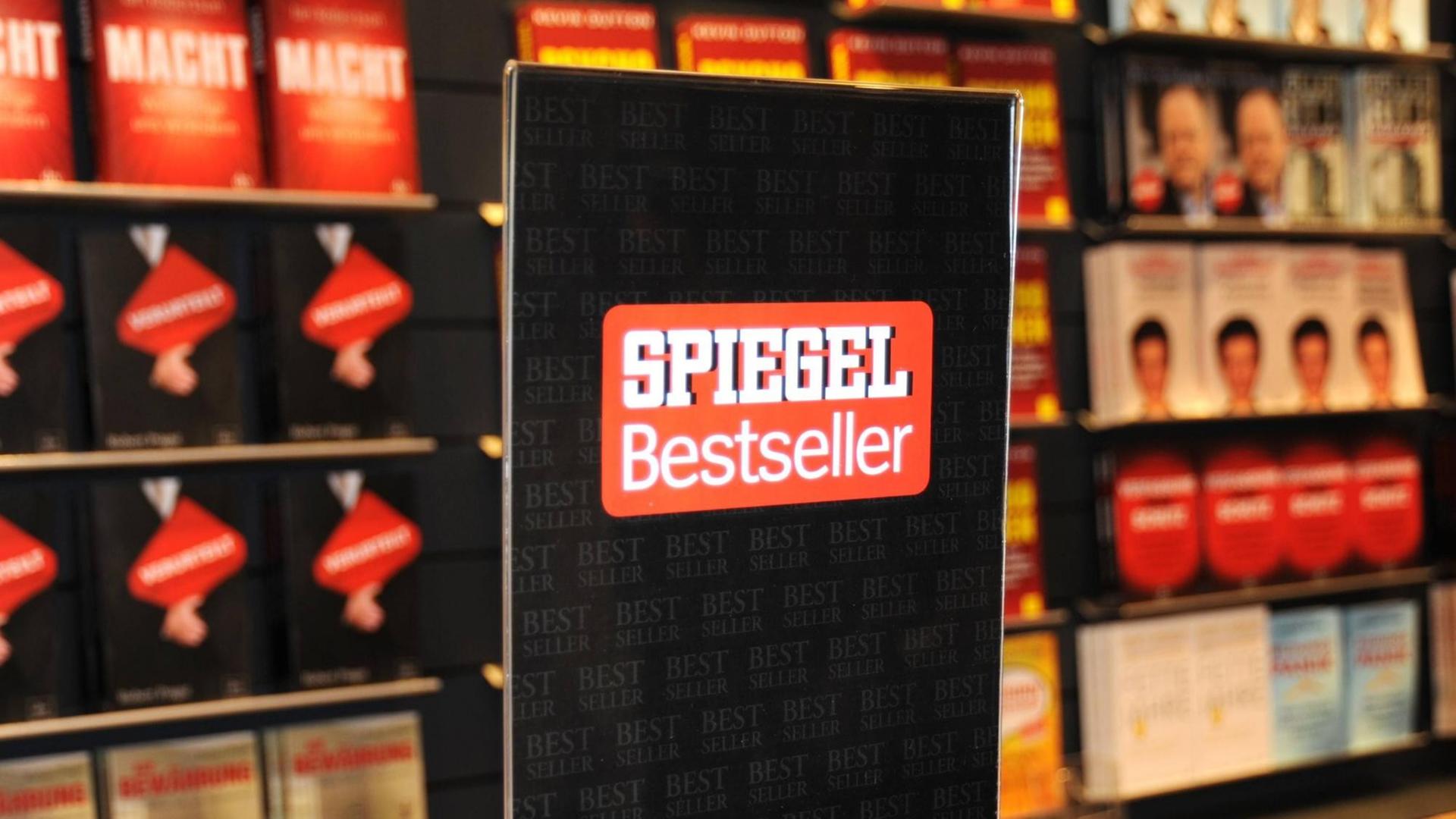 Ein Bücherregal mit Bestsellern auf der Frankfurter Buchmesse, davor ein Schild mit dem "Spiegel Bestseller" Logo.