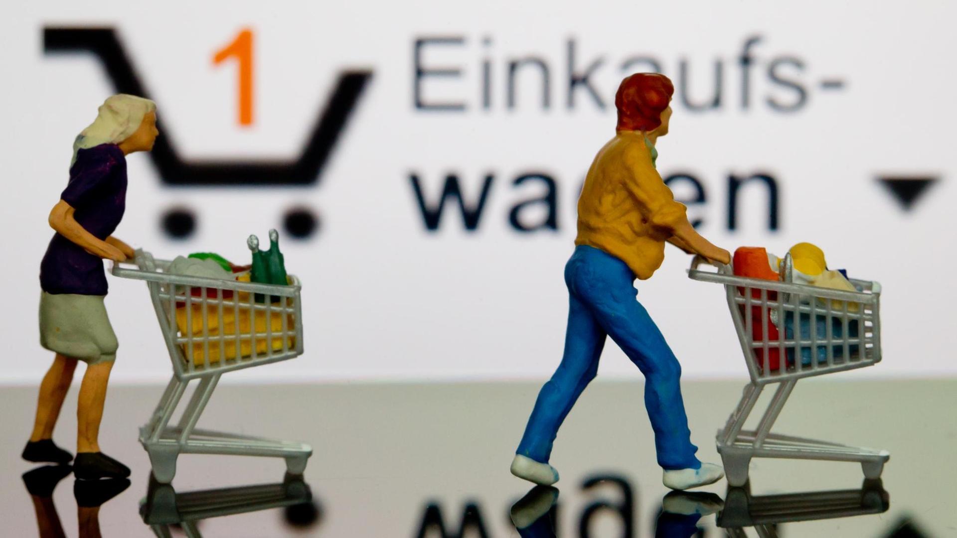 Zwei kleine Plastikfiguren mit Einkaufswagen stehen in Berlin vor einem iPhone auf dem der virtuelle Einkaufswagen dargestellt ist, aufgenommen am 06.11.2012.
