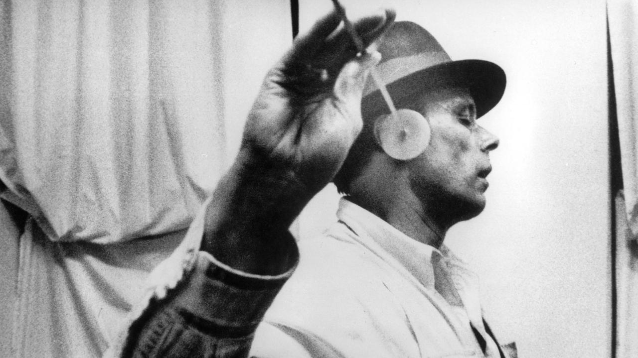 Joseph Beuys hält einen Ohrenkegel an sein rechtes Ohr, Ort unbekannt, undatiert, ca. Ende der 70er Jahre.