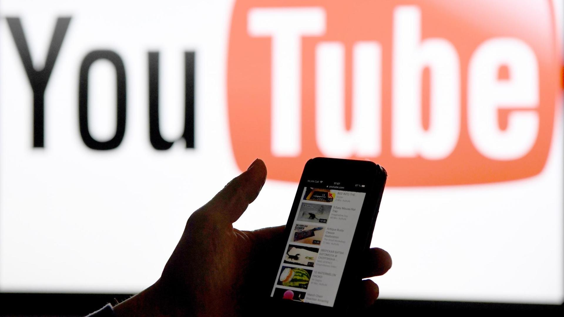 Ein Smartphone wird vor das Logo der Internet-Plattform YouTube gehalten. Foto: dpa