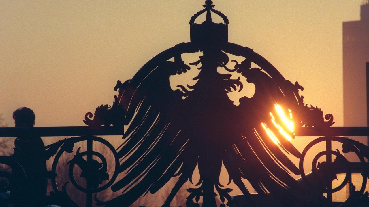Der goldene Glanz der aufgehenden Sonne streift den Preußischen Adler an der Weidendammer Brücke über die Spree an der Friedrichstraße in Berlin-Mitte.