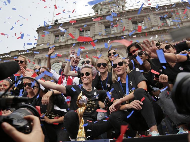USA, New York: Die Fußballerinnen der Frauenfußballmannschaft aus den USA mit Megan Rapinoe (M) feiern am Rathaus während einer Konfetti-Parade ihren WM-Erfolg. Die US-Nationalmannschaft besiegte die Niederlande mit 2:0 und holte damit den vierten Weltmeistertitel der Frauen.