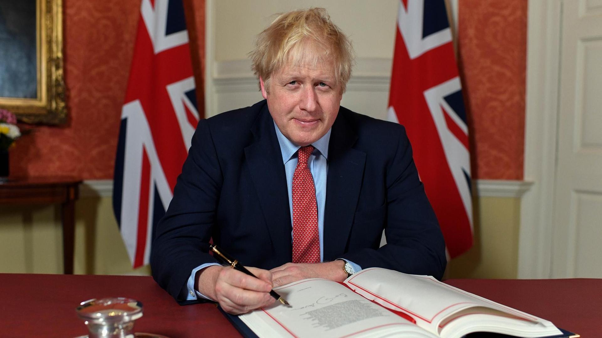 Das Bild zeigt Boris Johnson. Der Premierminister von Großbritannien unterzeichnet das EU-Austrittsabkommen