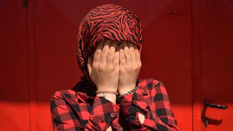 Eine iranische Flüchlingsfrau schlägt die Hände vors Gesicht. Das Bild entstand in einem Foto-Workshop für Flüchtlinge in Belgrad, den das Zentrum für kulturelle Dekontamination veranstaltet hat 