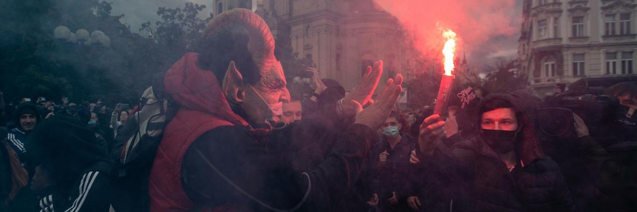 Das Foto zeigt Demonstrierende in Prag, die Pyrotechnik entzünden.