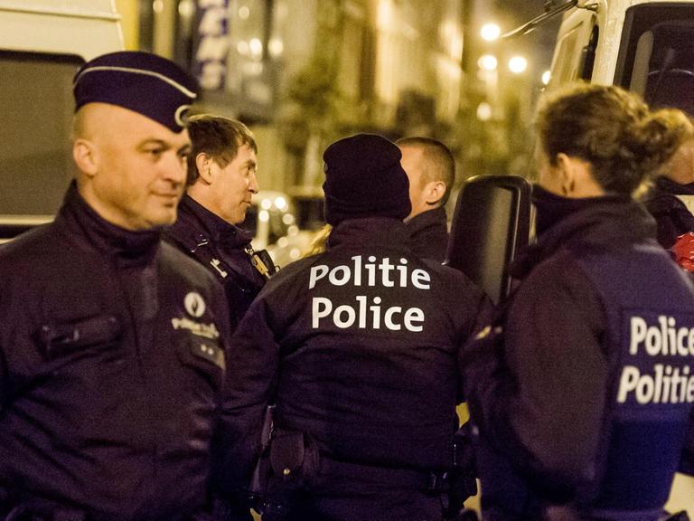 Belgische Polizisten stehen im Brüsseler Stadtteil Anderlecht vor einer Wohnung, nachdem drei Männer festgenommen wurden.