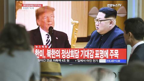 In einer Bahnstation in Seoul verfolgen Menschen einen TV-Beitrag mit Kim und Trump