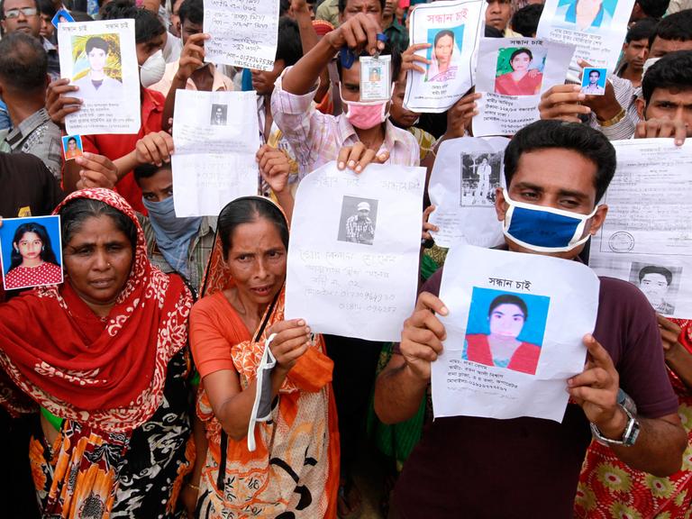 Nach dem Einsturz einer Textilfabrik: Demonstranten zeigen Fotos ihrer toten oder vermissten Verwandten in Savar, Bangladesch.