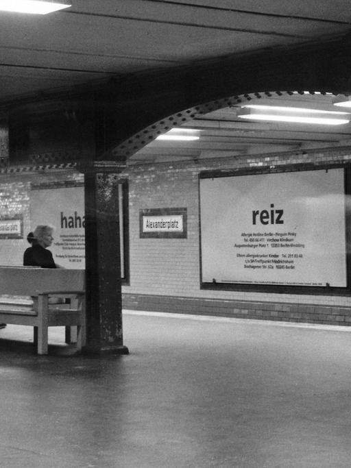 Bahnhof der Linie U2 am Berliner Alexanderplatz. Wartende Menschen, die 1998 einem großen Plakat mit dem Aufdruck "Reiz" am u-Bahn-Gleis gegenübersitzen.