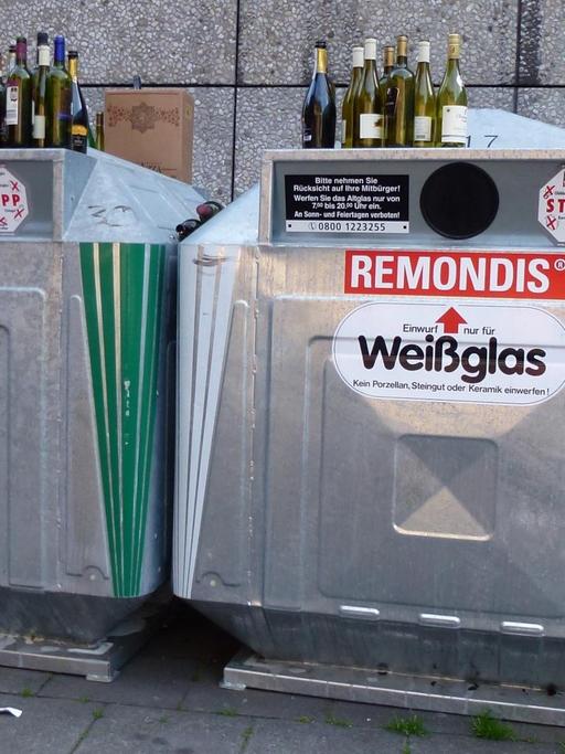 Leere Flaschen stehen auf überfüllten Altglascontainern, aufgenommen am 06.04.2014 in Köln.