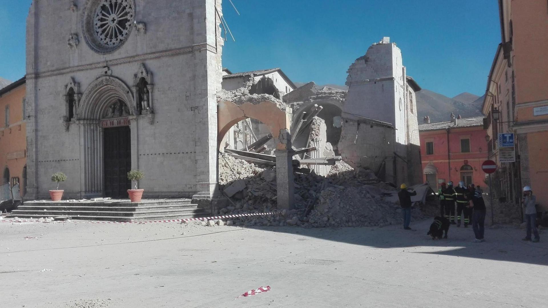 Das Bild zeigt die bei einem Erdbeben zerstörte Kirche des Heiligen Benedikt in der italienischen Stadt Norcia. Das Eingangsportal ist unversehrt. Das Bild zeigt die bei einem Erdbeben zerstörte Kirche des Heiligen Benedikt in der italienischen Stadt Norcia. Das Eingangsportal ist unversehrt.