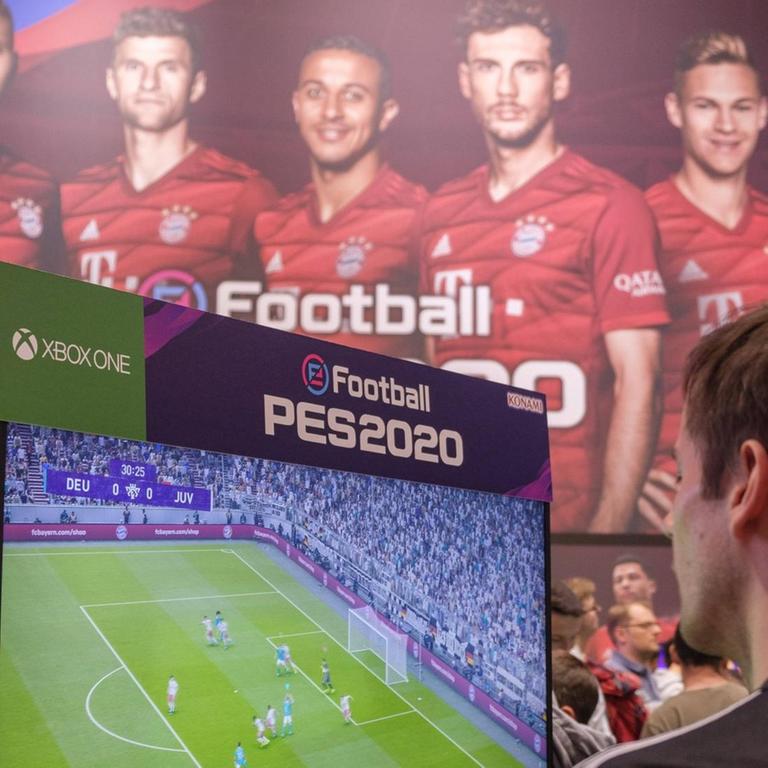 Spieler spielen das Spiel PES 2020 (Pro Evolution Soccer) vor Portraits einiger Spieler des FC Bayern München. 