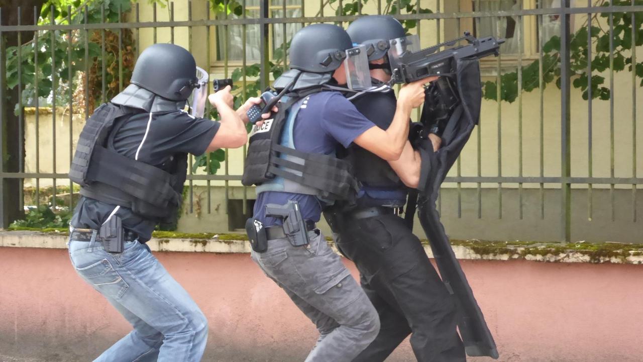 Französische Polizisten trainieren mit Waffen in den Händen an der Polizeischule.
