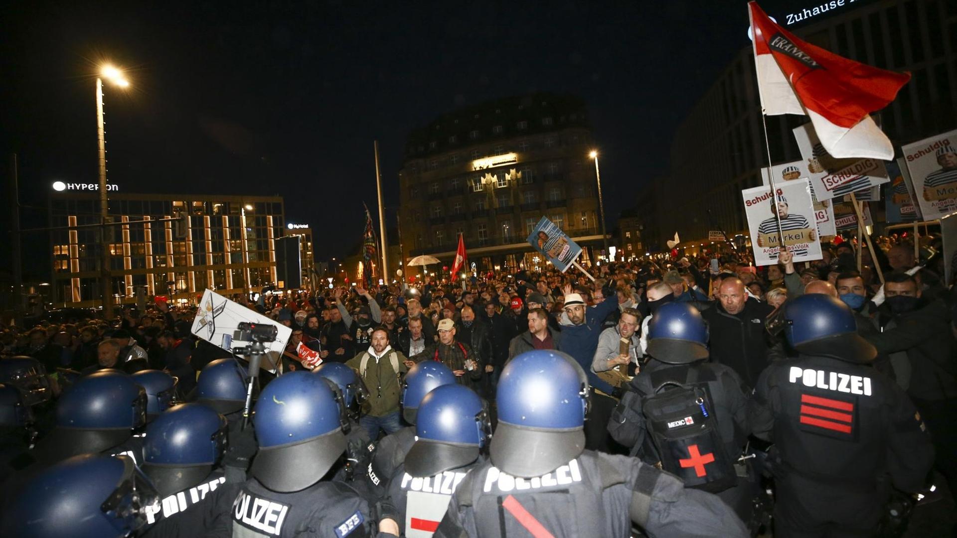 Polizeibeamte stehen in Leipzig Teilnehmern einer Demonstration gegen die Corona-Maßnahmen gegenüber