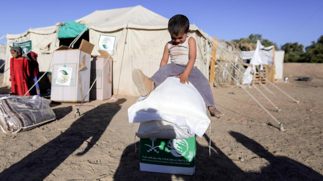 Ein vertriebenes jemenitisches Kind sitzt am 26. Januar 2018 auf Boxen und Säcken von Nahrungsmittel in einem Lagerder nordöstlichen Provinz Marib.