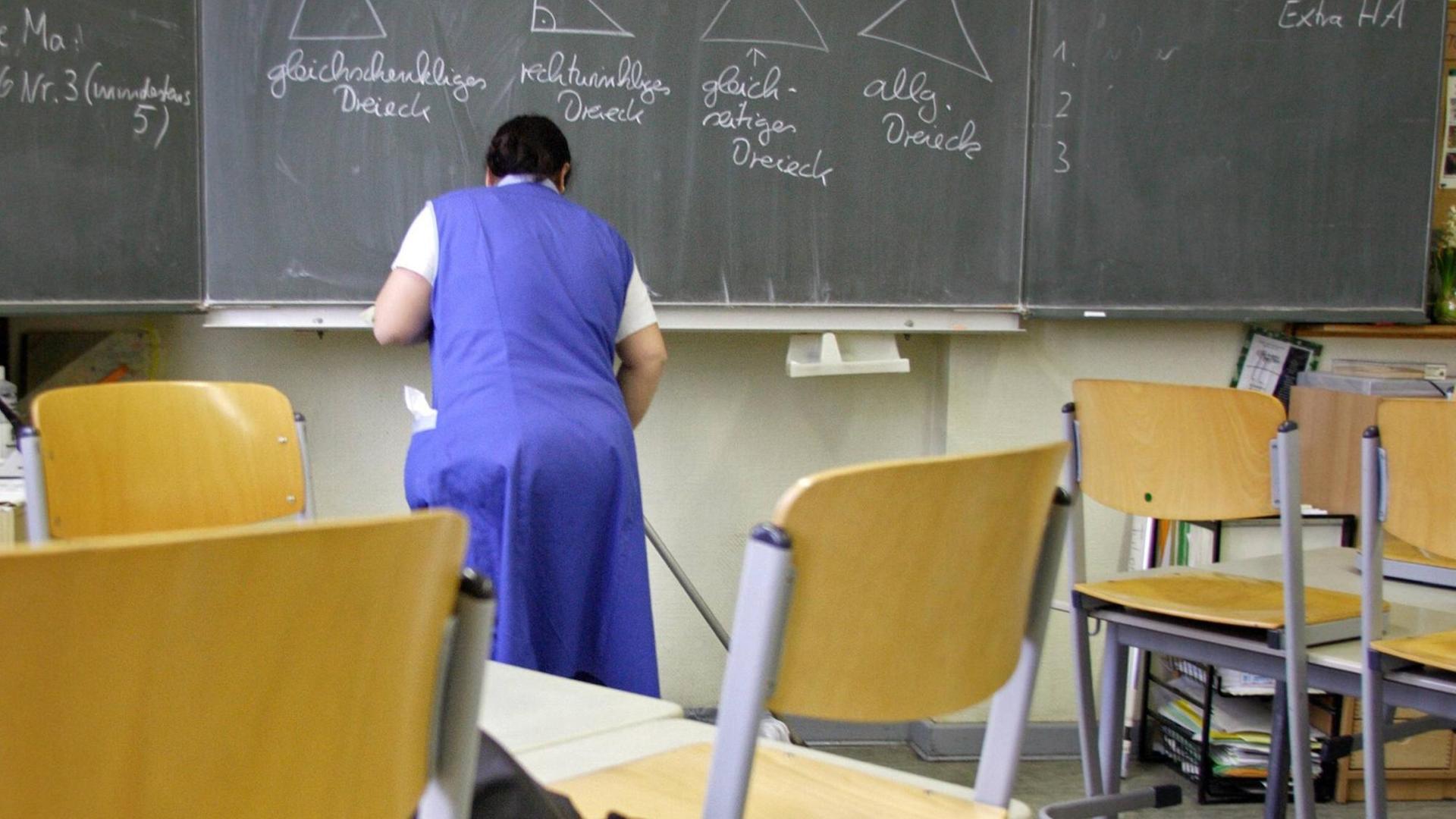 Eine Putzfrau reinigt ein Klassenzimmer in einer Grundschule in Berlin-Tempelhof.