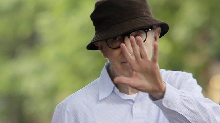 Woody Allen mit einer abwehrenden Handbewegung, mit der sein Gesicht verdeckt wird.